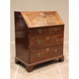 A George III mahogany bureau, the fall front opening to an arrangement of pigeon holes and
