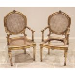 A pair of Louis XV style giltwood and rattan elbow chairs, 19th century, each with an oval cane work