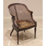 An ebonised bergere tub chair, late 19th/early 20th century, the down swept back rail extending to