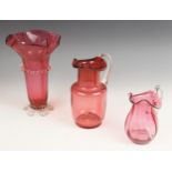 A cranberry glass vase, 19th century, with flared folded rim and prunted central band and feet,