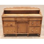 A Victorian pine dresser base, the shaped three quarter gallery with a single shelf above the