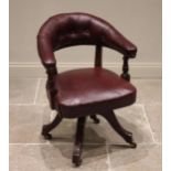 A Victorian mahogany and red leather captain's chair, the arched button back extending to padded