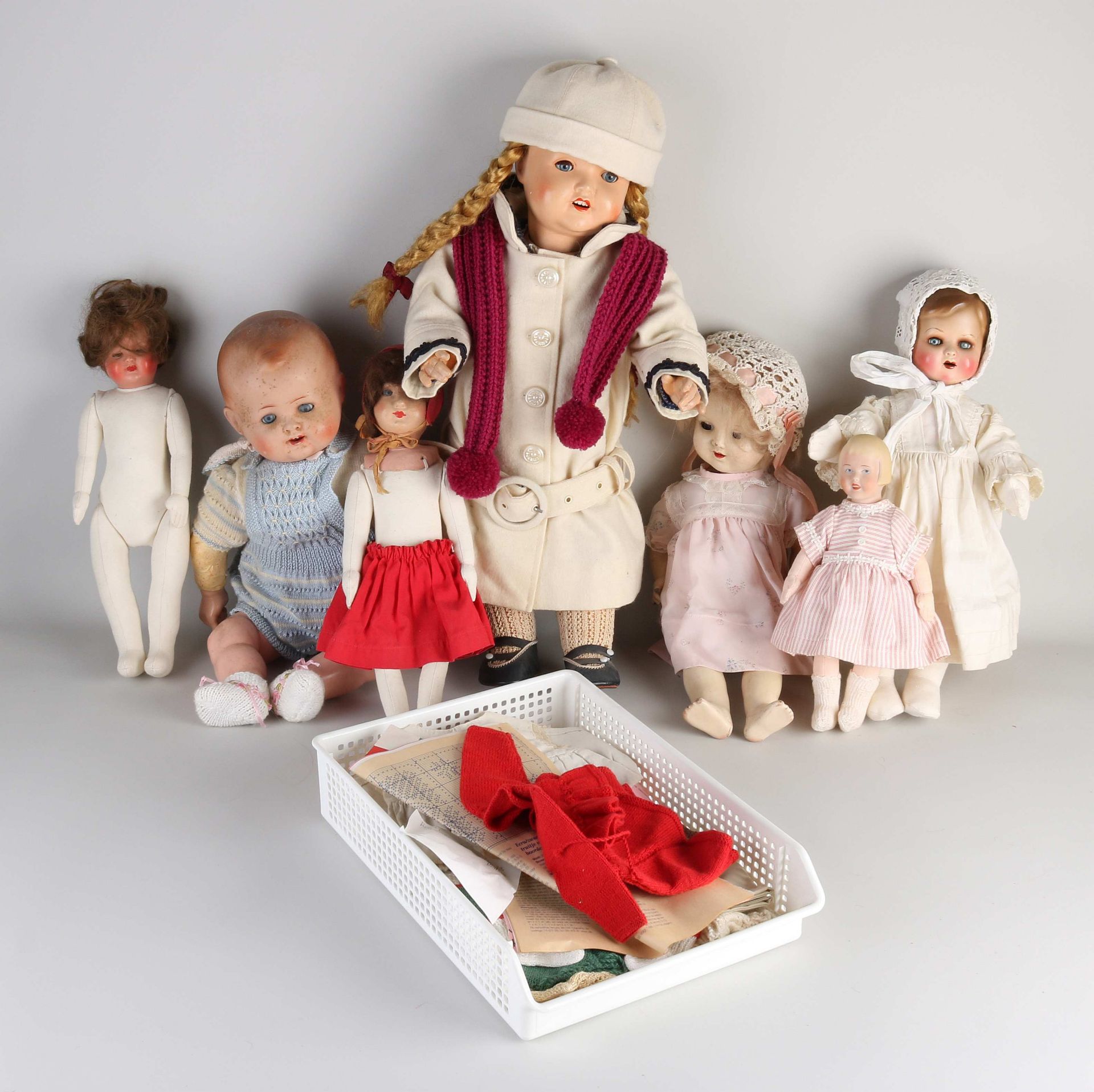 Seven antique dolls + doll clothes