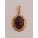 Gold pendant with garnet