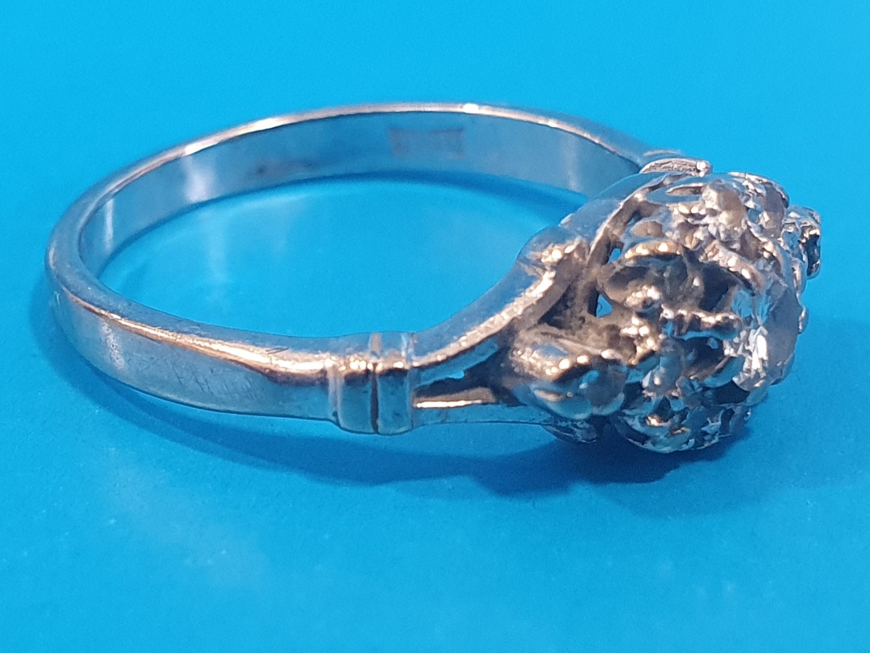 18ct White Gold and Diamond Ring set with 11 small diamonds and 1 larger. Total weight is 3.64g,