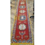 A Colourful Runner Wool Rug Measuring 144 inches x 32 inches.  Some wear apparent.