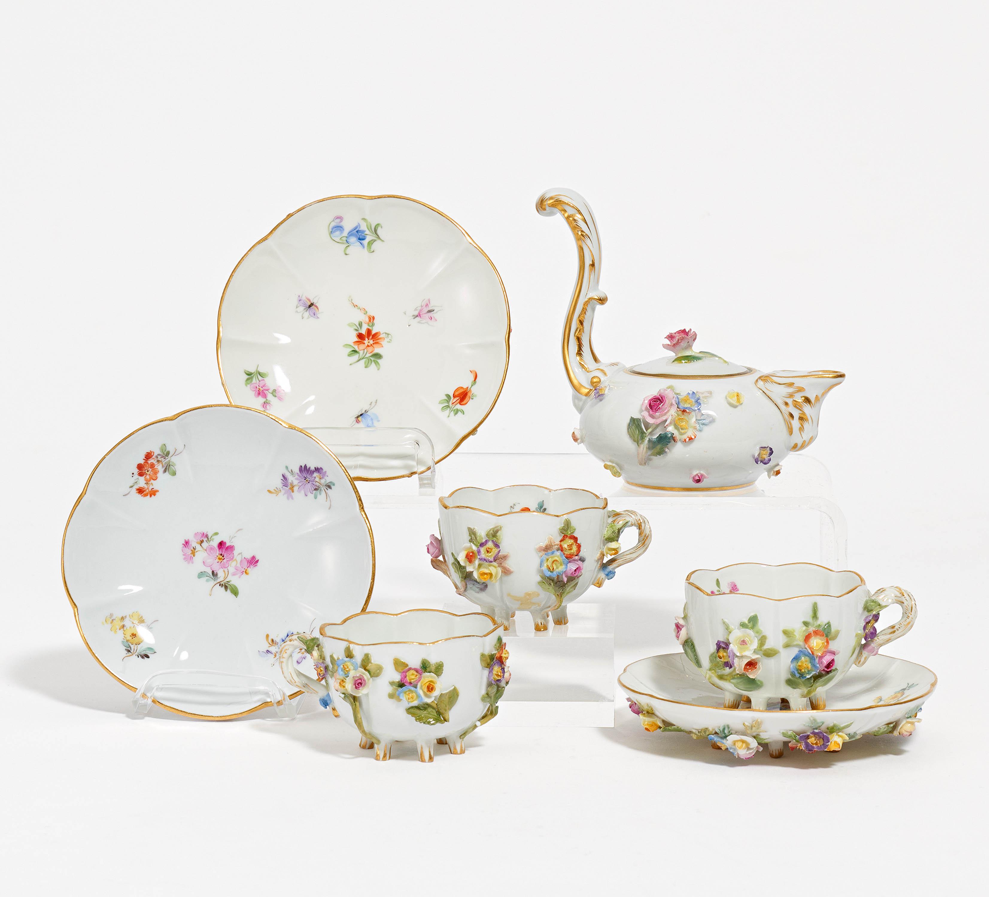 Jug and three cups with saucers decorated with applied flowers