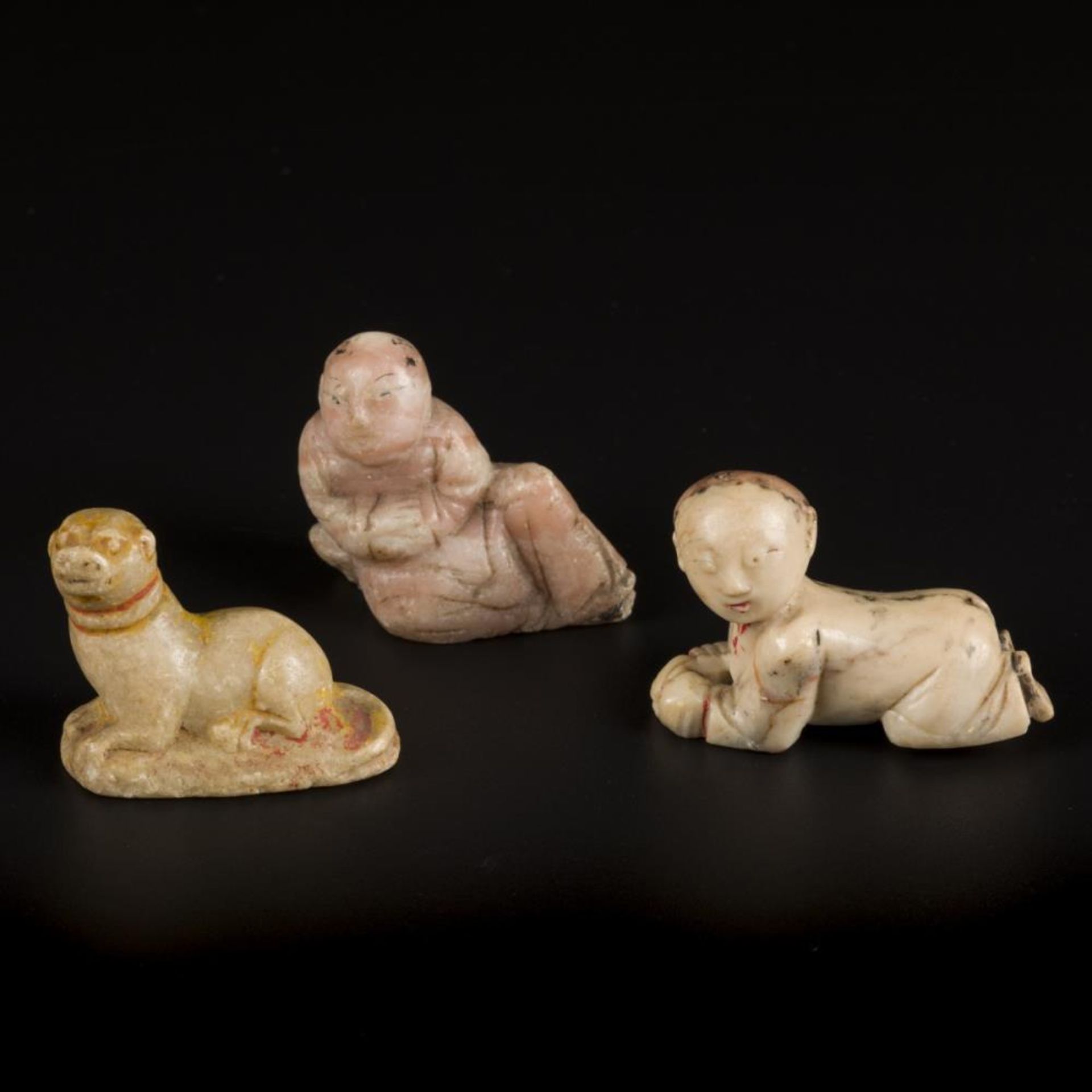 A lot of (3) soapstone figurines in the shape of a crawling and sitting man and a reclining dog. Asi