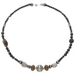 Gemstone necklace set with, among other things, lava stone and smoky quartz.