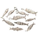 Lot of 8 silver flexible fish pendants, including one perfume pendant, and one pair of earrings.