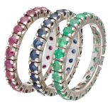 Set of three 18K. white gold eternity rings set with natural ruby, sapphire and emerald.