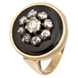 Vintage 14K. yellow gold ring with a diamond in a silver setting on a black plaque.