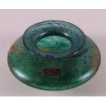 A green iridescent vase with embedded blue/yellow spots, Austen Hand Labor.