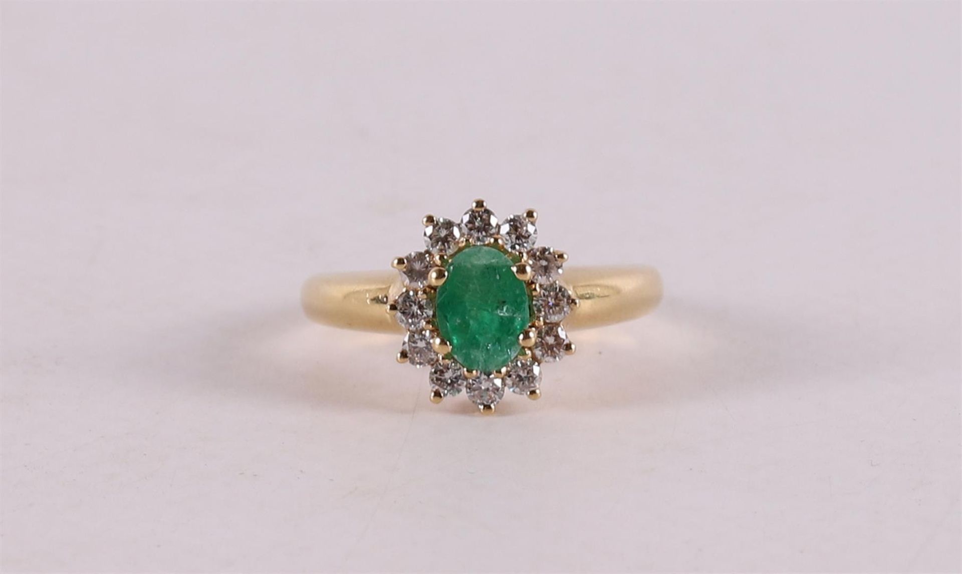 An 18 kt gold ring with an oval facet cut emerald.