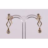 A pair of 14 kt gold earrings with 4 diamonds.