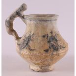 An earthenware jug with a stylized animal as a handle, 14th century.
