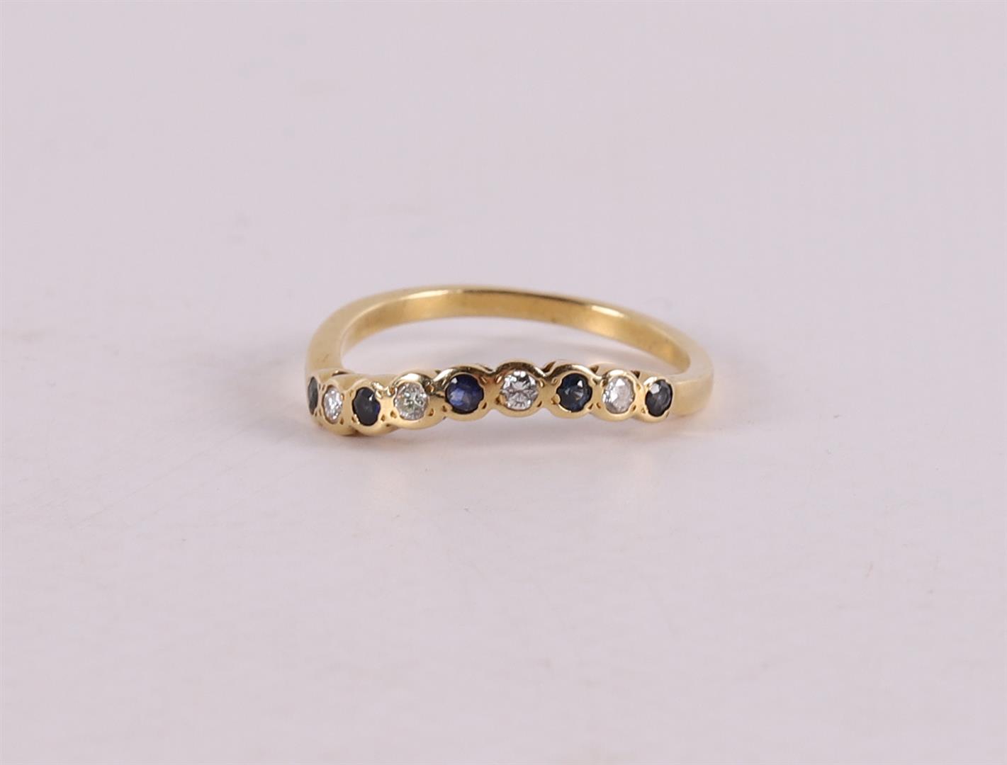 An 18 kt gold ring with 5 facet cut blue sapphires and 4 diamonds.