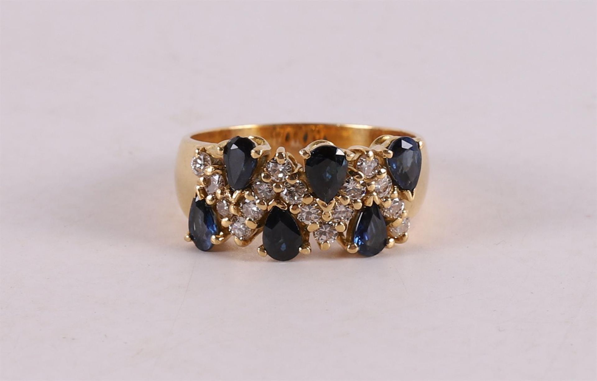 An 18 kt gold band ring with 6 blue sapphires and 16 diamonds