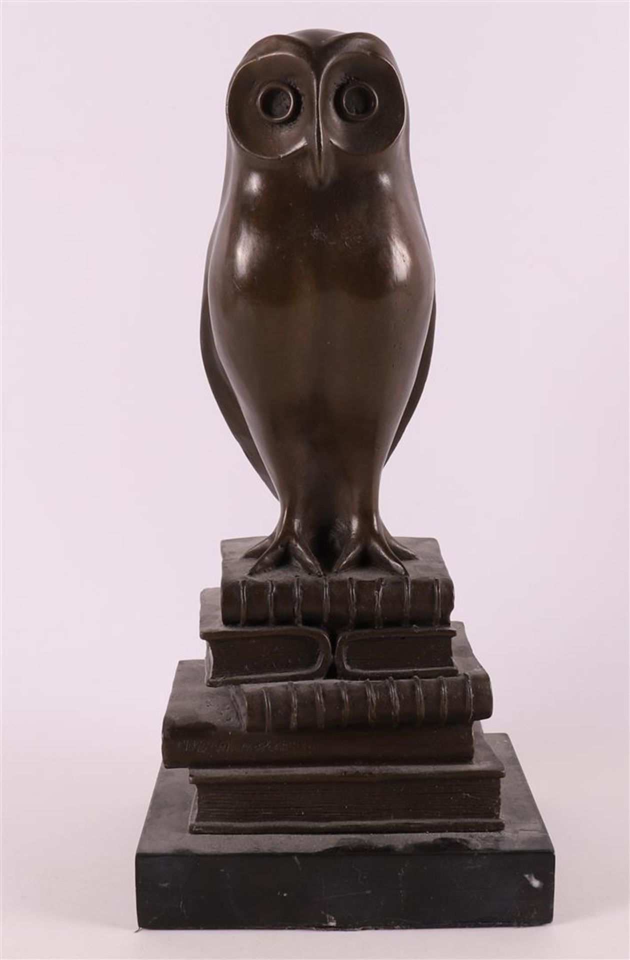 A brown patinated bronze owl sitting on books, Art Deco style.