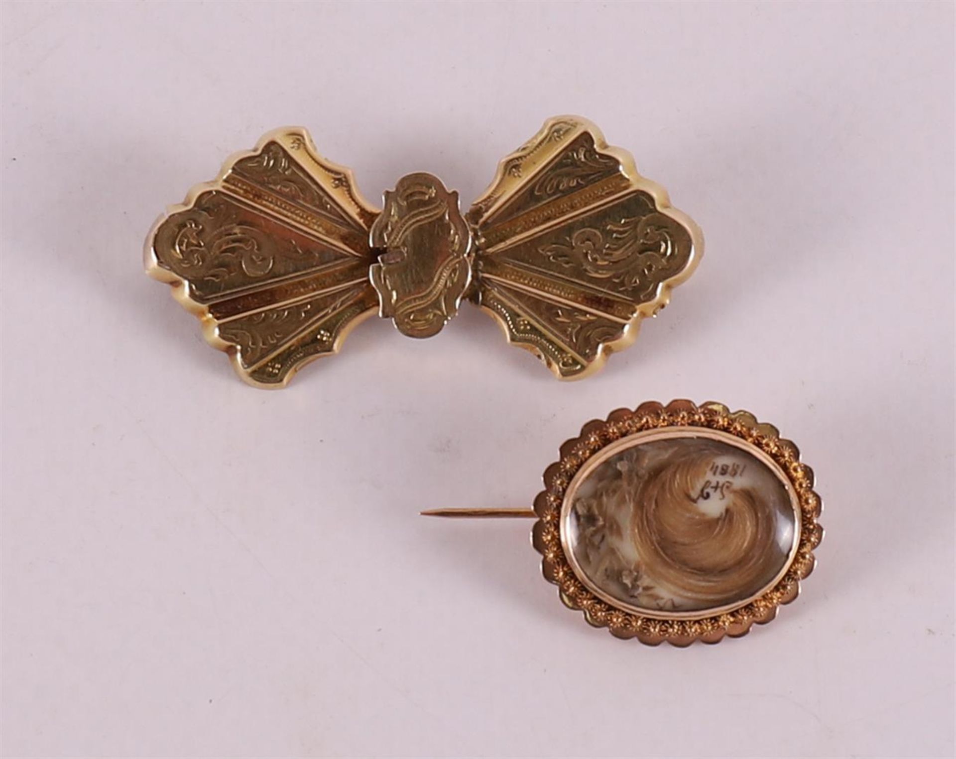 A 14 kt 585/1000 gold brooch with hair, regional costume dated 1884.