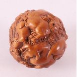 A carved tropical wooden ball with animals, including monkeys, rabbit, etc. Chin