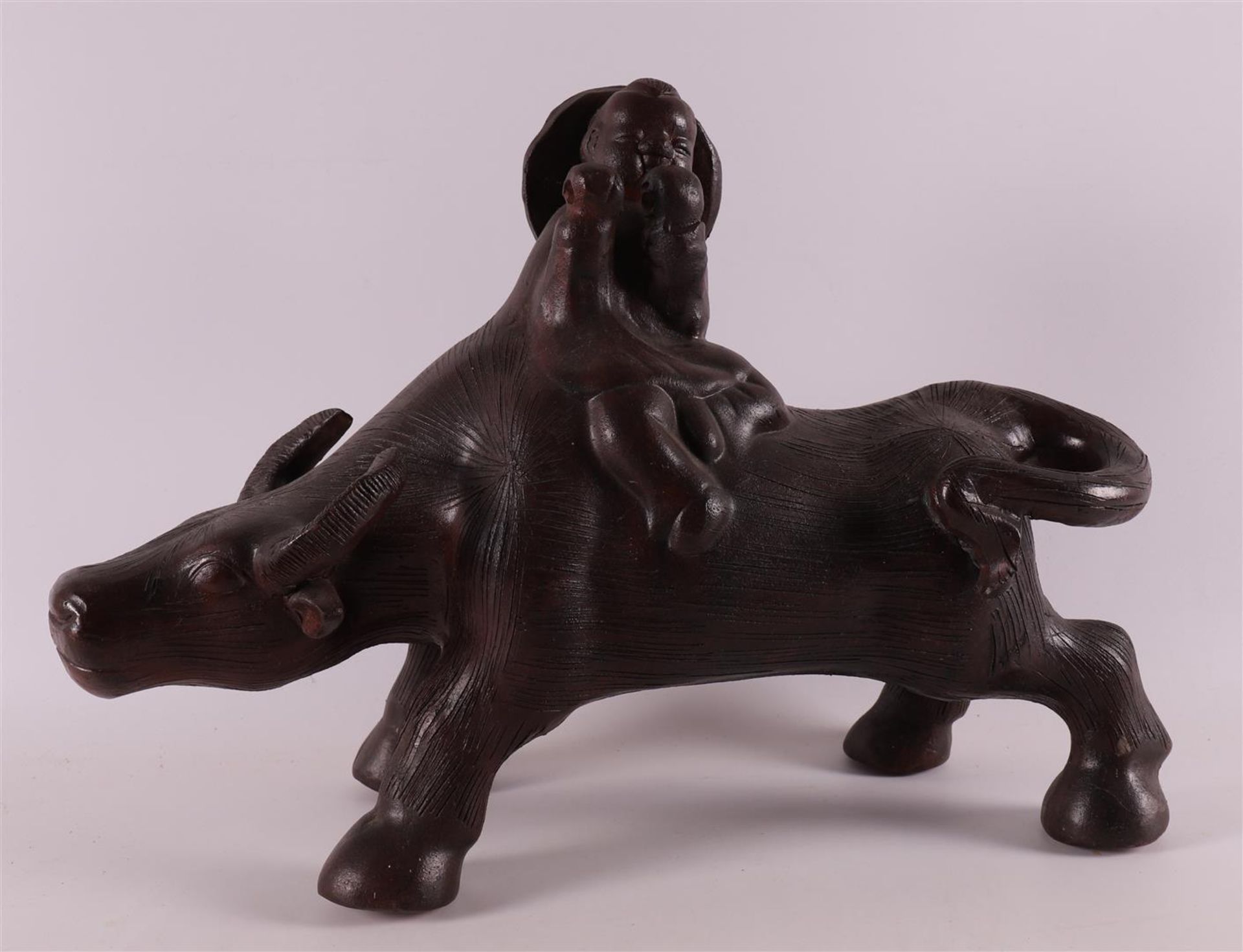 A stoneware water buffalo with a fool on its back, China, 21st century.