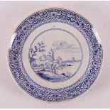 A blue and white earthenware plate depicting figures in a landscape, 19th centur