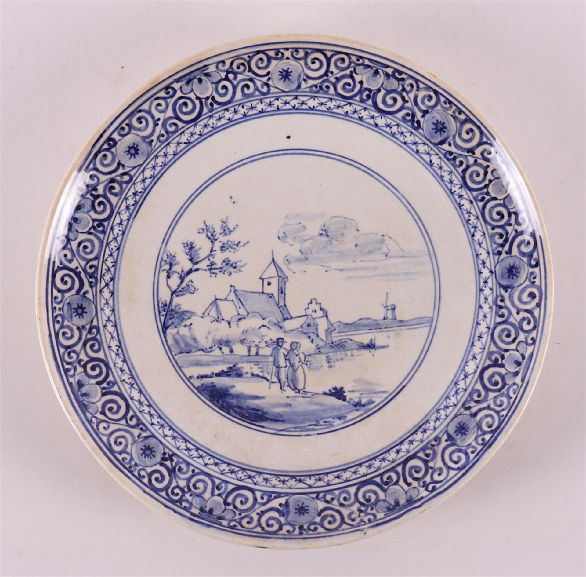 A blue and white earthenware plate depicting figures in a landscape, 19th centur