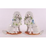 A pair of porcelain poodles with baskets, 20th C.