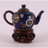 A cloisonné miniature teapot on loose wooden base, China, around 1900.