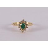 An 18 kt gold ring with an oval faceted emerald and entourage.