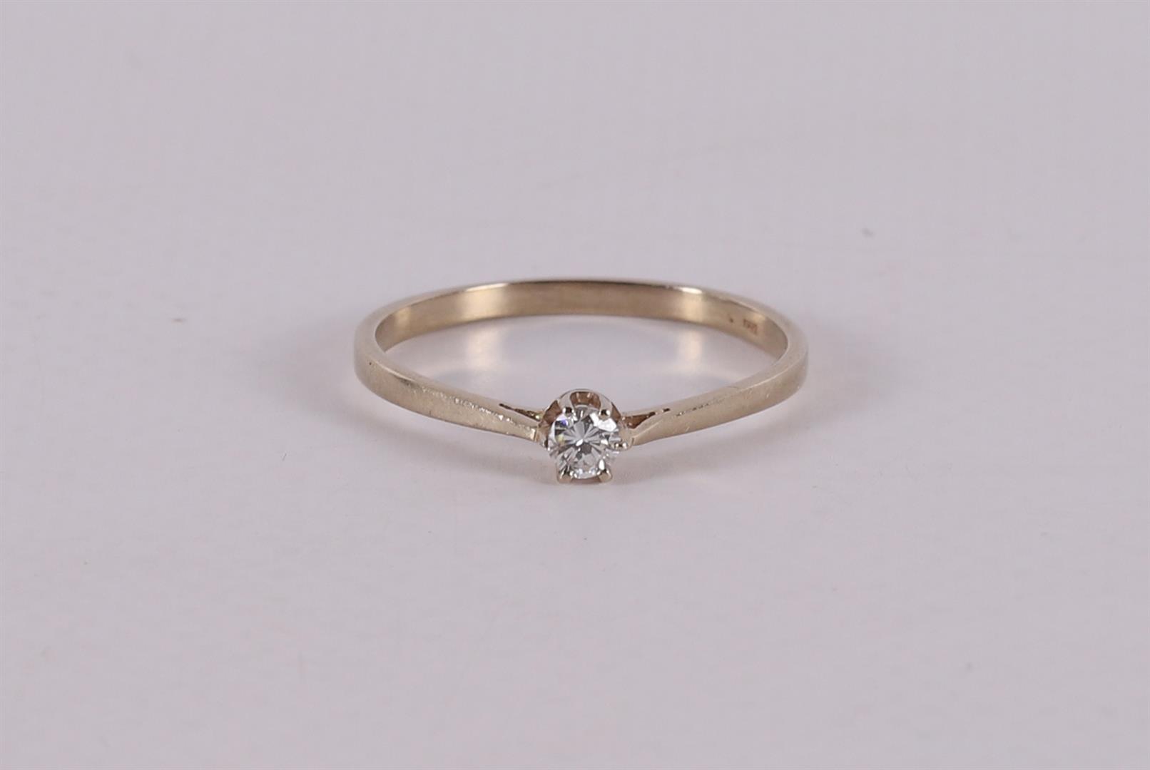 A 14 carat gold solitaire ring with a brilliant.