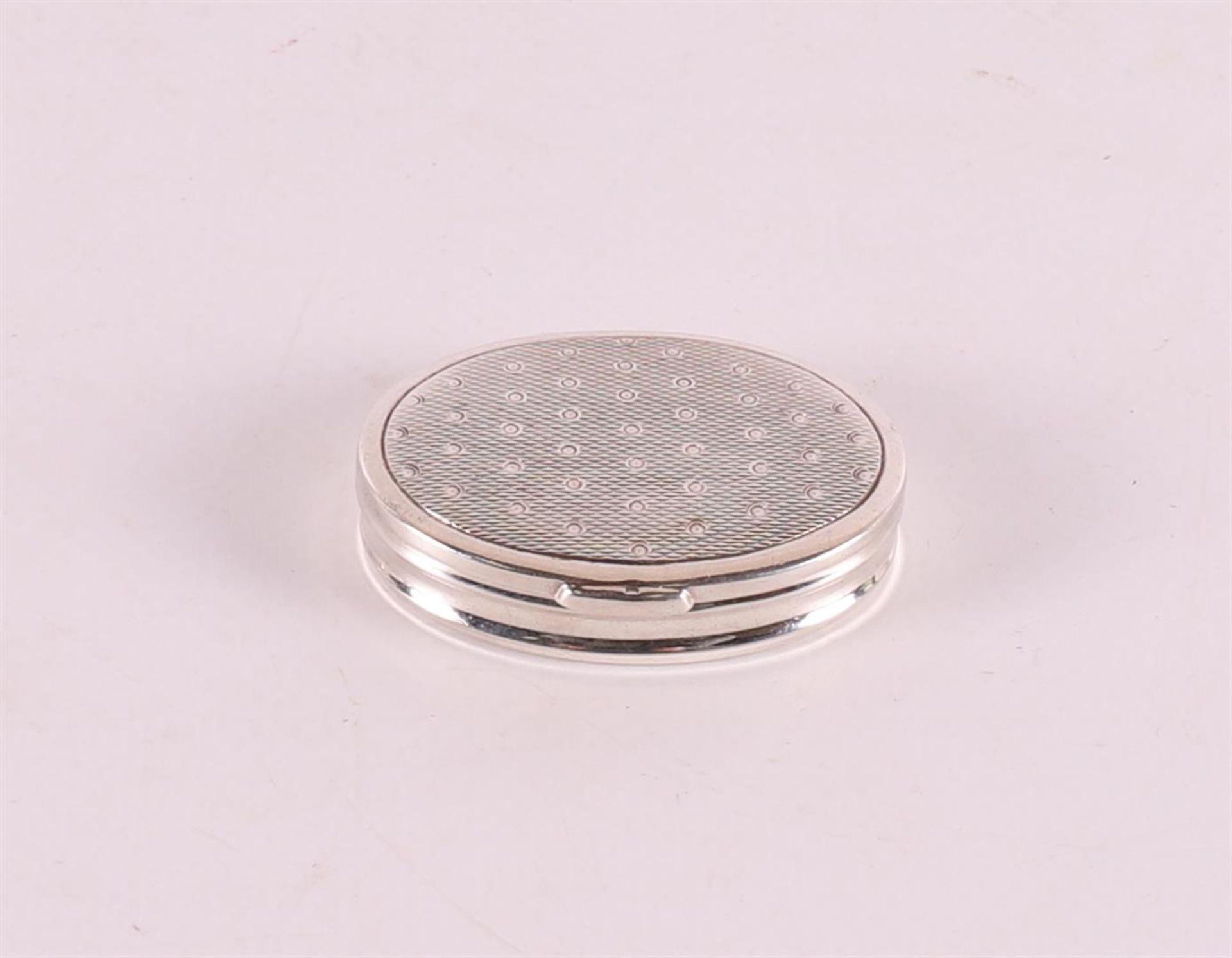 An oval second grade silver pill box, wavy decor with dots.