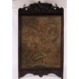 A wall embroidery in a carved wooden frame with bird and flora, 19th century.
