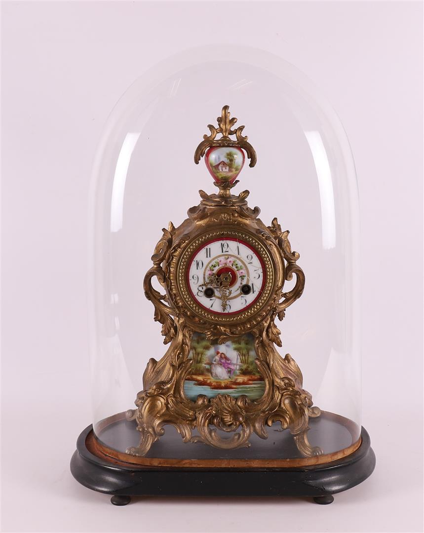 A gilded white metal mantel clock under a glass bell jar, France, 19th century.