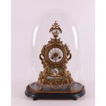 A gilded white metal mantel clock under a glass bell jar, France, 19th century.