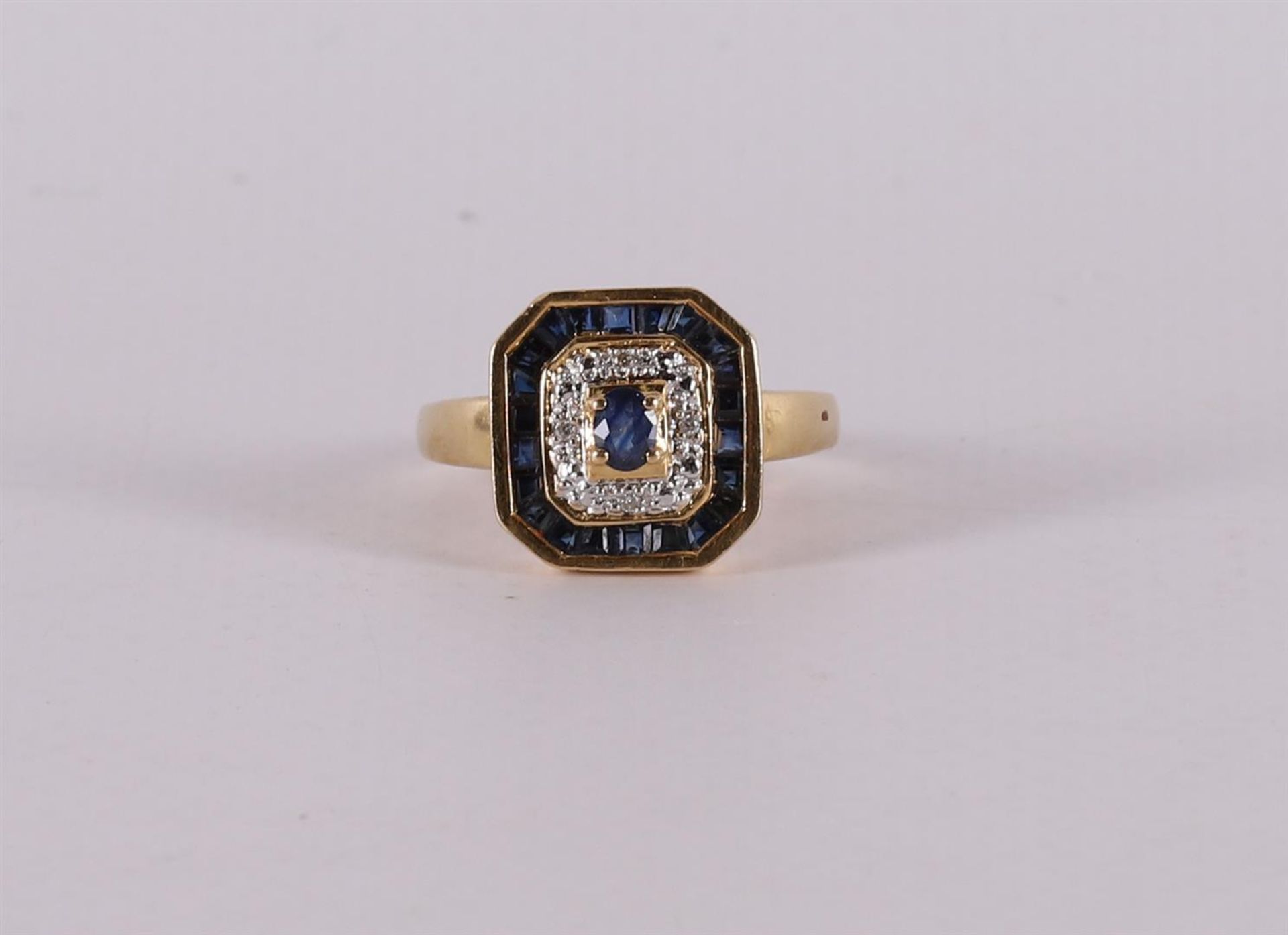 An 18 kt gold ring with facet cut blue sapphires and brilliants.