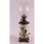 A white metal and earthenware table lamp with satined glass shade, 19th century