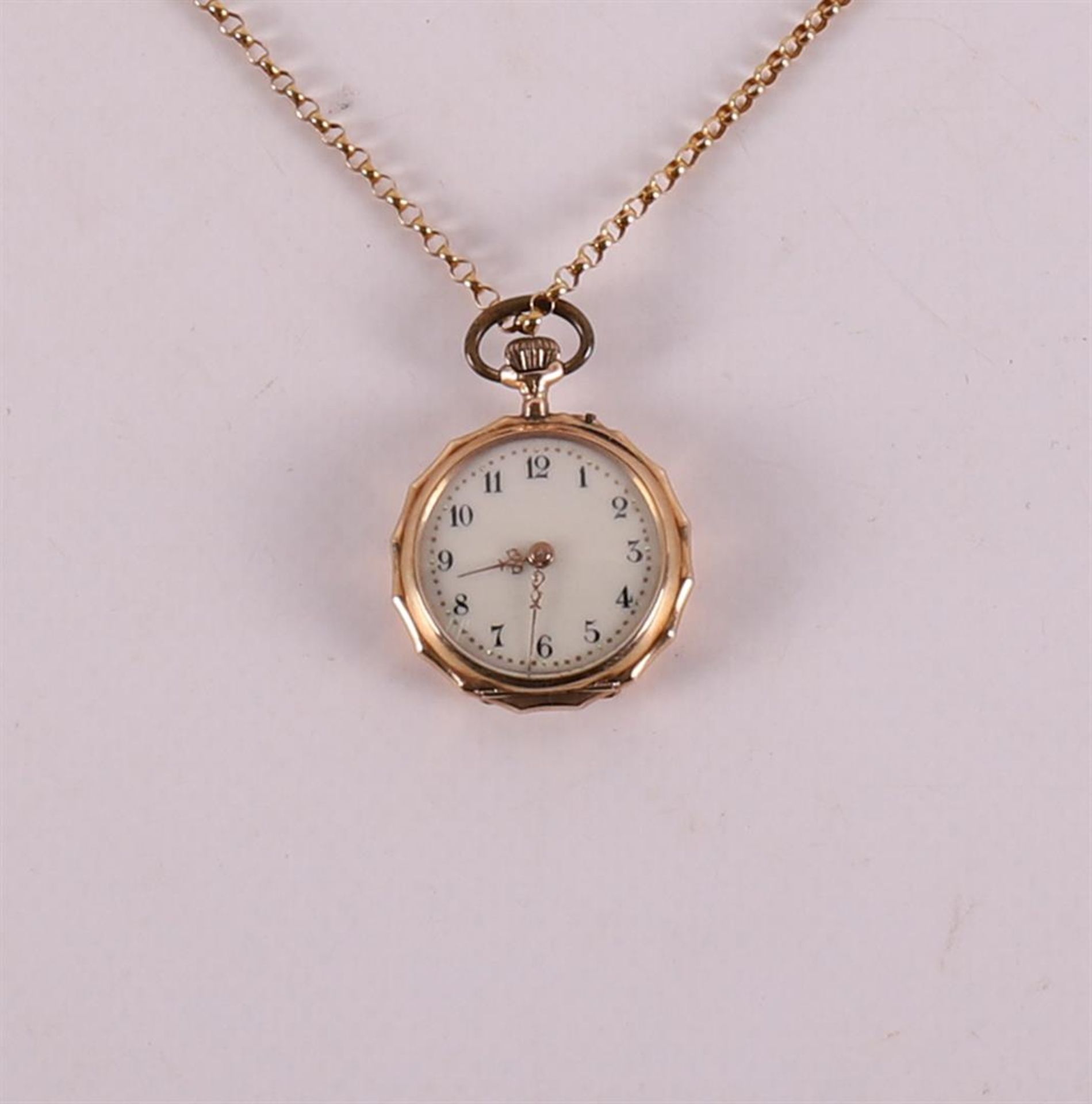 A women's pendant watch in 14 kt yellow gold engraved case, on a gold necklace,