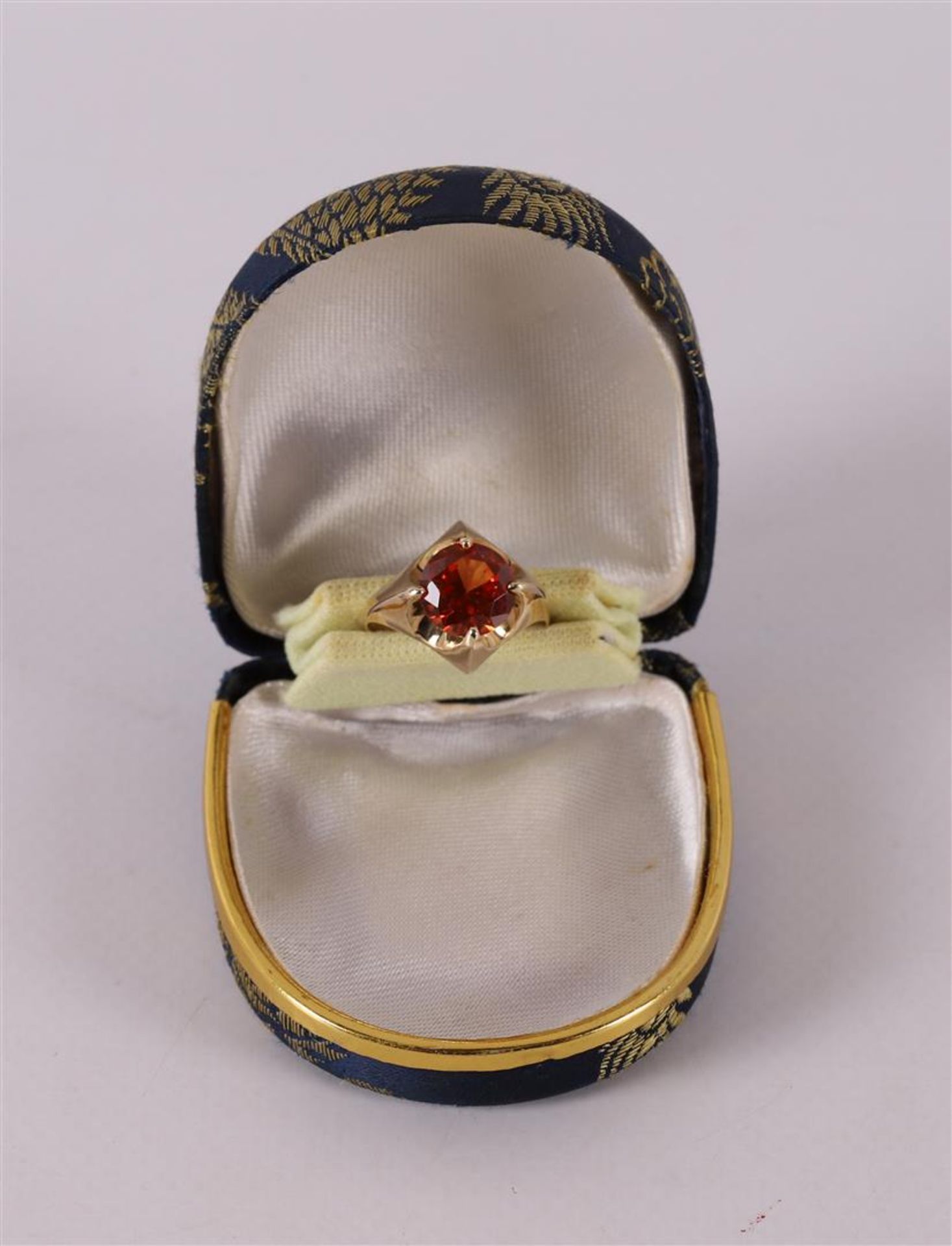 A 14 kt 585 yellow gold ring, set with diamond-cut red sapphire.