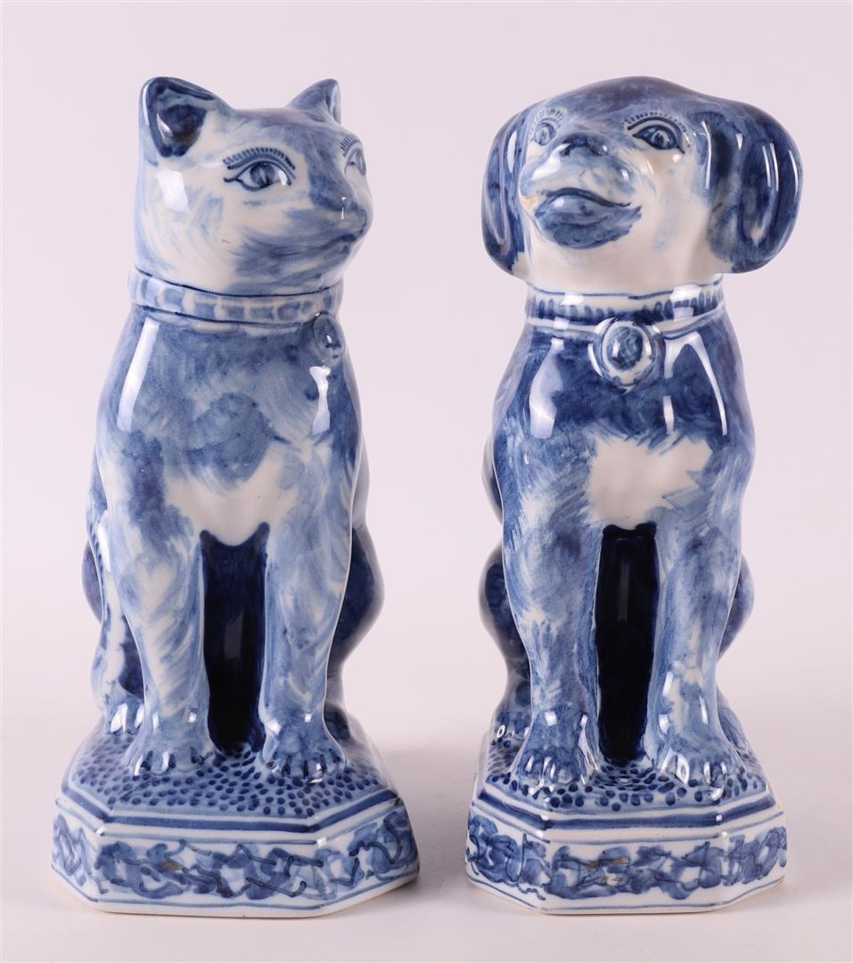 A blue and white earthenware seated dog and cat, Makkum, Tichelaar, 20th century