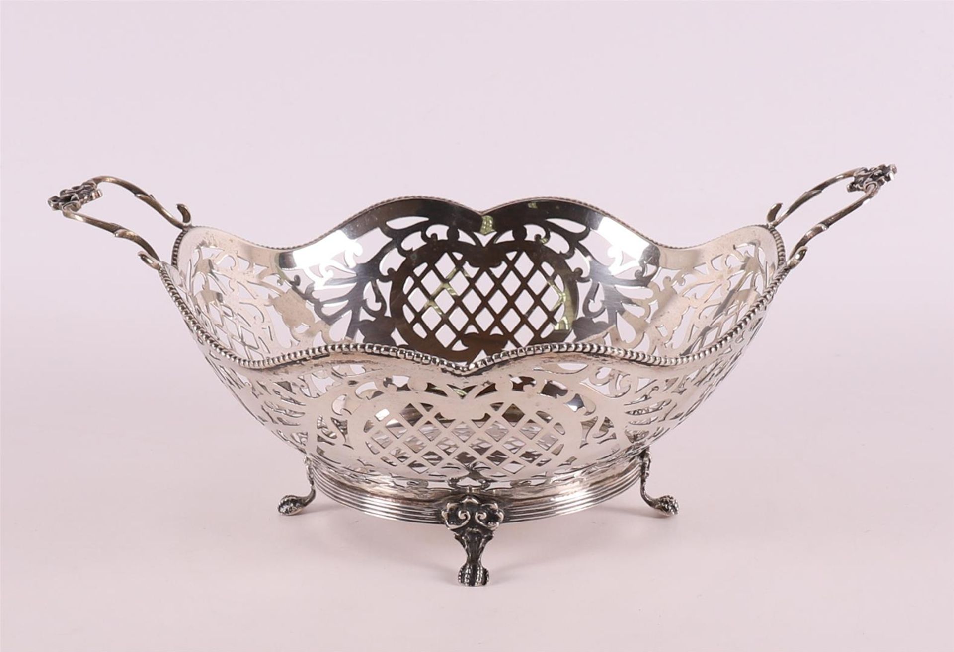 A pierced 2nd grade silver choux basket with handles and pearl rim.