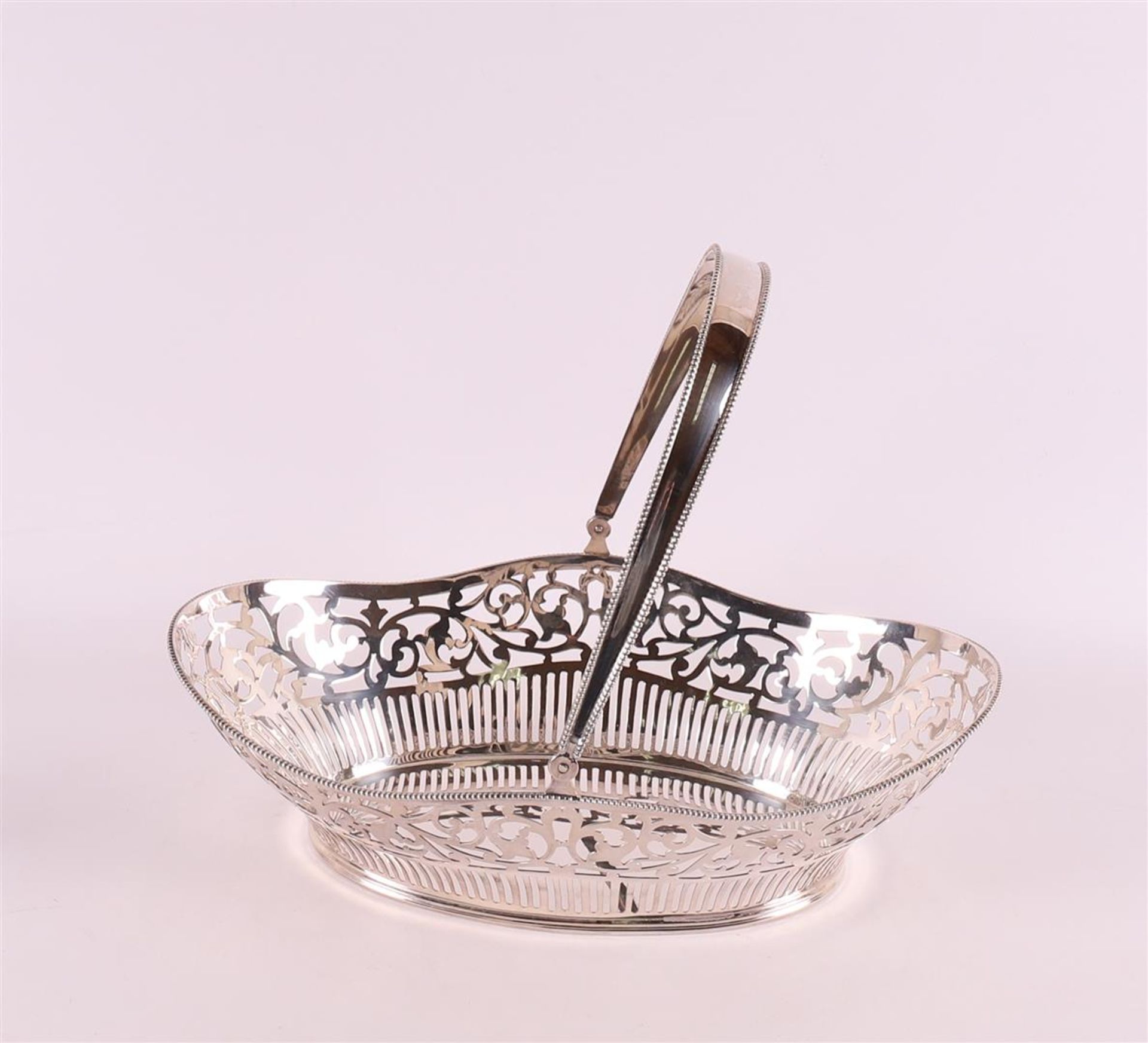 A pierced second grade silver bread basket with handle and pearl rim