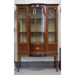 A display cabinet with curved front door, England, circa 1900.