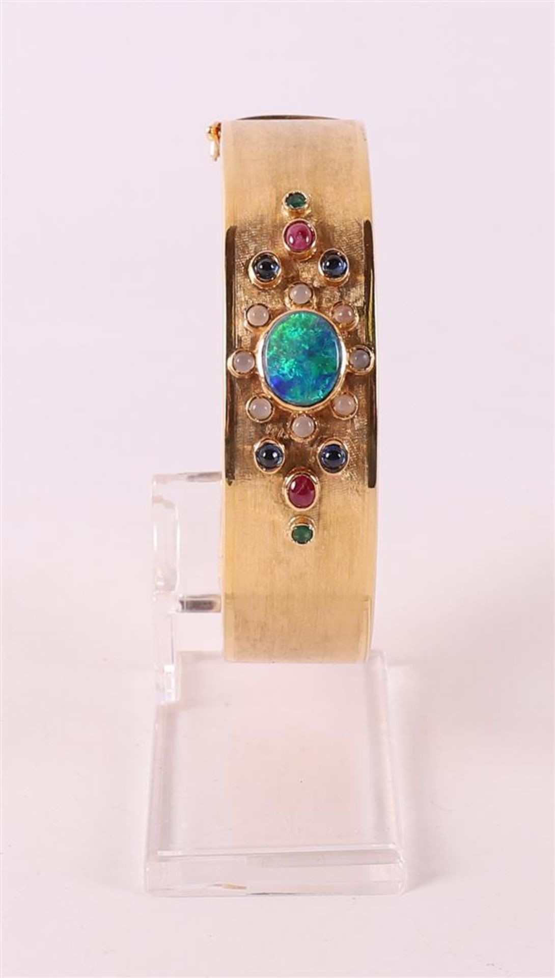 A 14 kt 585/1000 yellow gold rigid bracelet, set with various colored stones.