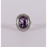 An 18 carat gold ring with an oval faceted amethyst and diamonds.