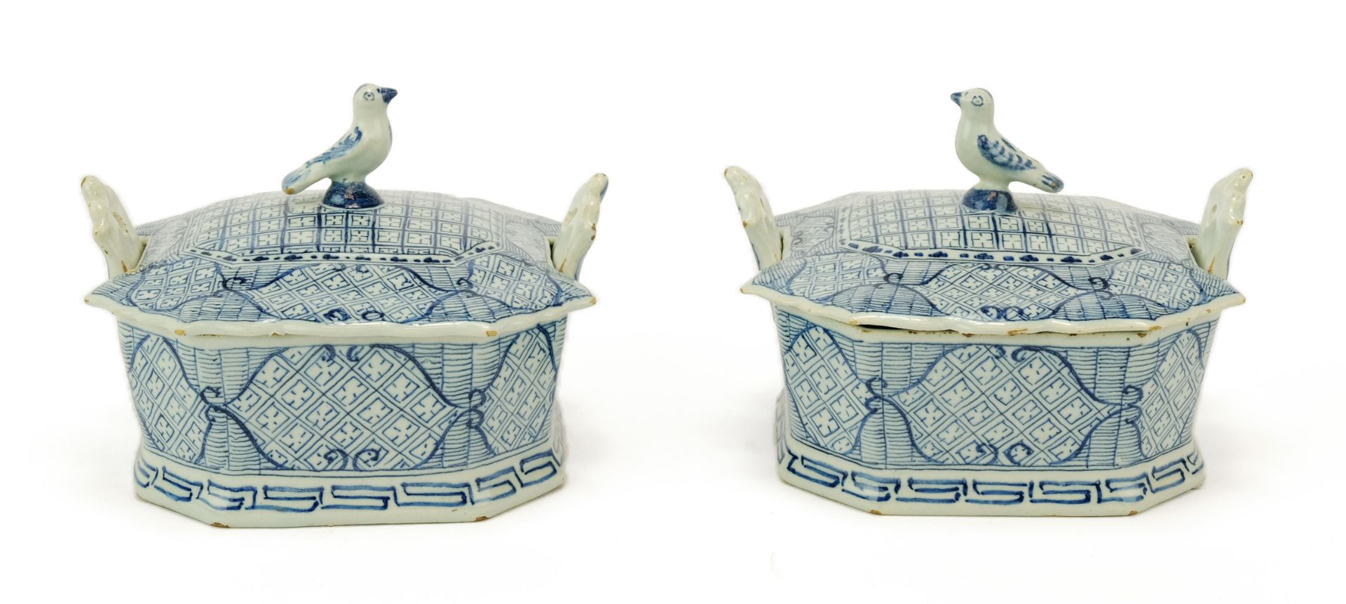 A pair of Dutch Delft blue and white butter dishes with bird finials