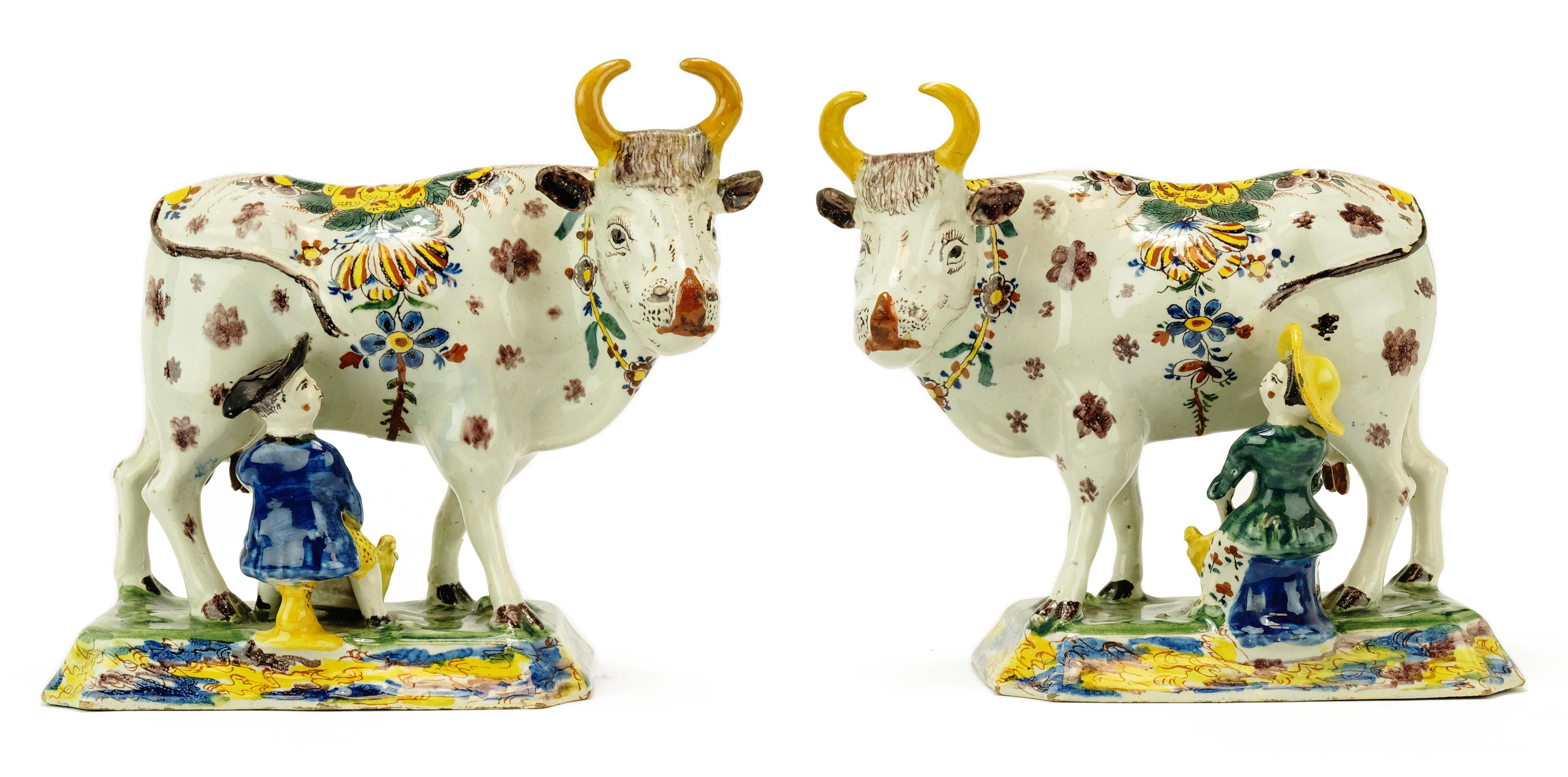 A pair of Dutch polychrome Delft pottery cow milkers