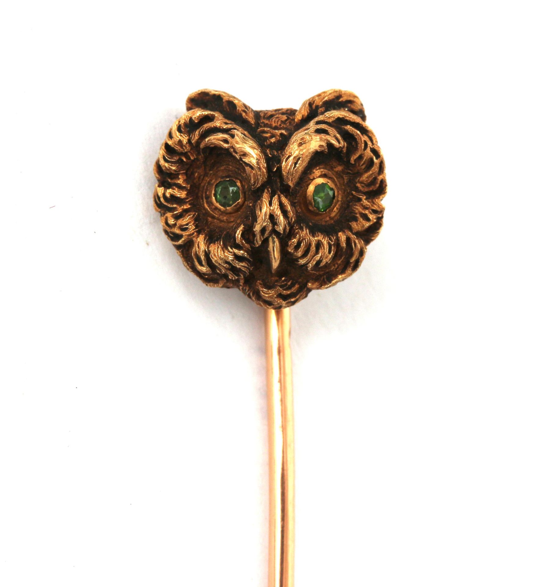 An 14 karat gold pin in the shape of an owl