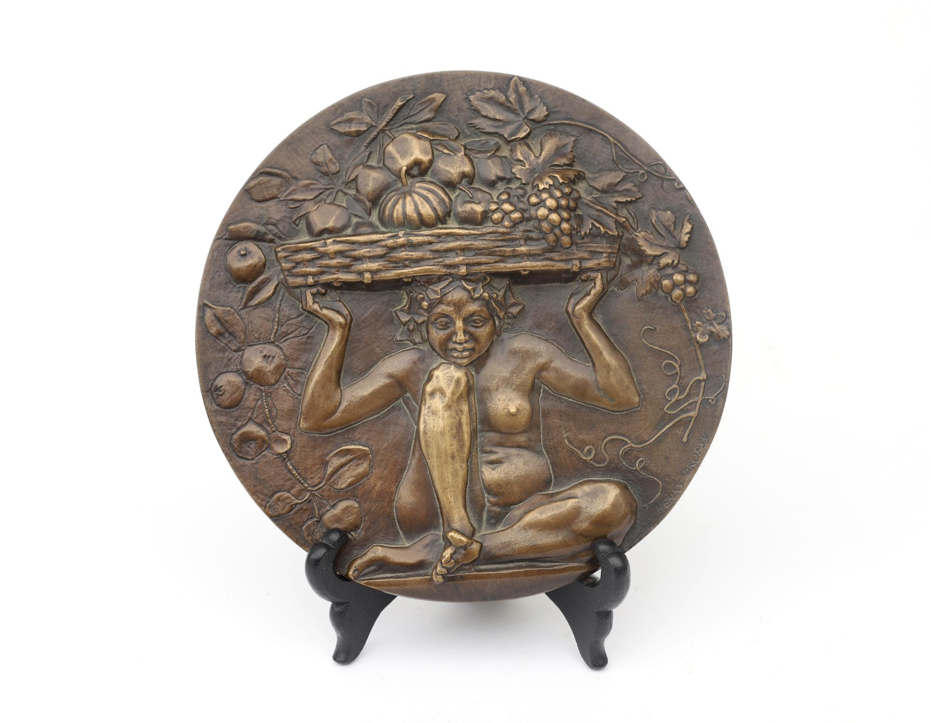 Henry Dropsy (1885-1969) A circular bronze plaque depicting a seated female nude with a fruit-filled